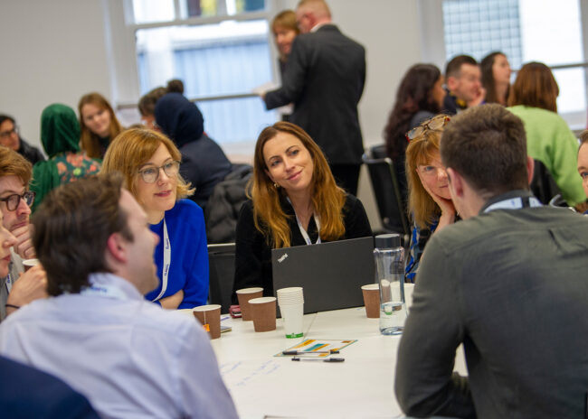 A table of Belong Network members in discussion at a networking event.