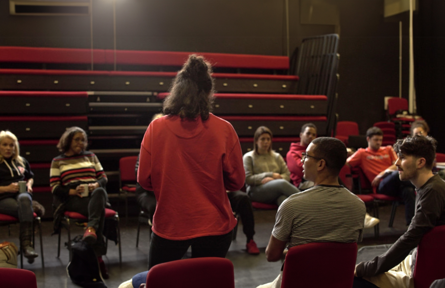 A photograph of a group of young people in conversation.